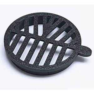 Round black metal drainage cover on white.