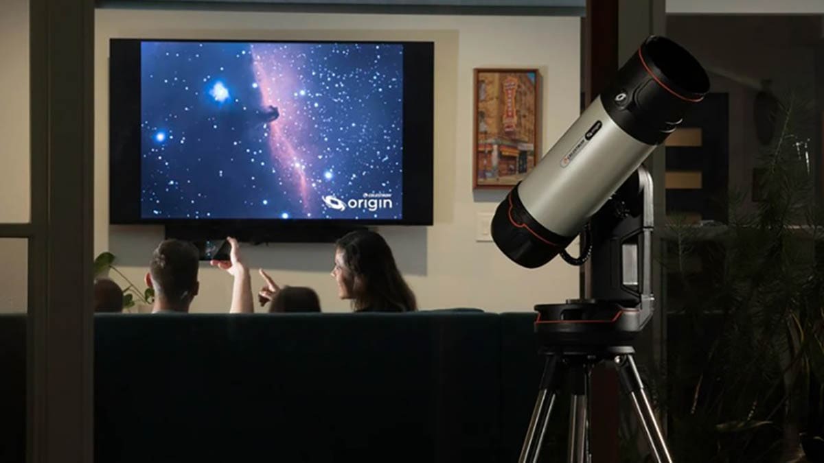People watch a cosmic scene on a large screen with a telescope nearby.